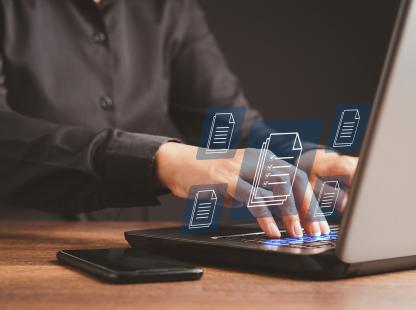 Businessman working at a laptop and digital documents with checkbox lists on virtual screen. Online documentation database and digital file storage concept